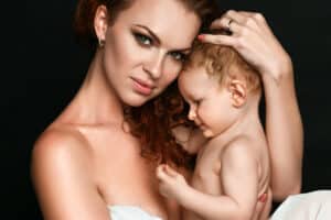 A beautiful young mom poses in a portrait with her young baby