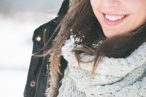 brunette girl smiling, snow on her hair
