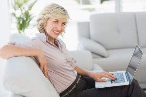 Side view portrait of beautiful businesswoman using laptop in the living room at home