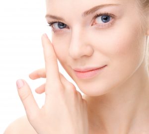 Young beauty woman portrait. Studio shot. Girl Touching her Face. Isolate on white. Health Care, cosmetic concept. Blank for commercial advertising