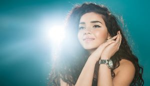 Attractive woman on a blue background with a spot of sunlight