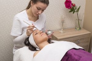 Young beautiful woman gets facial mask