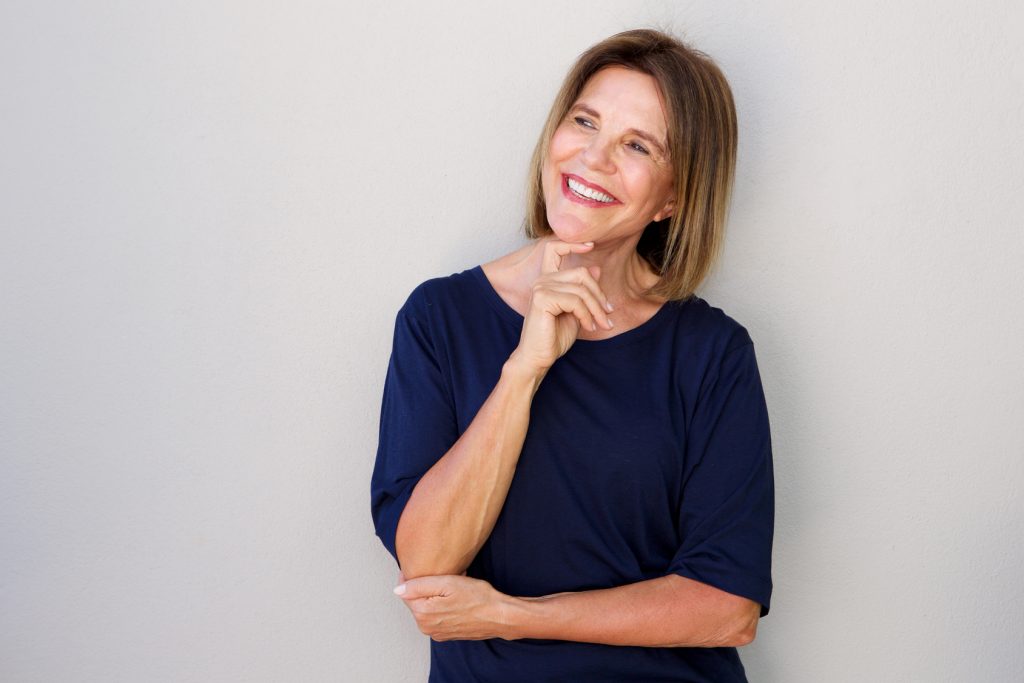happy older woman with hand to chin