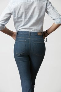 Woman's butt in slim fit jeans, on white background
