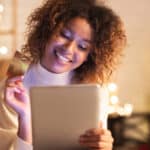 Excited afro woman ordering Christmas gifts