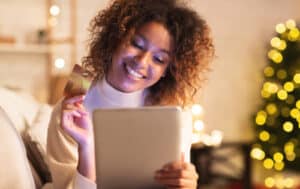 Excited afro woman ordering Christmas gifts
