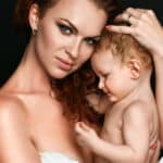 A beautiful young mom poses in a portrait with her young baby