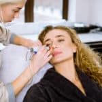 Professional female cosmetologist doing hydrafacial procedure