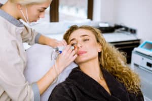 Professional female cosmetologist doing hydrafacial procedure