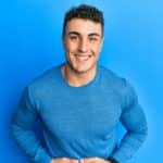 Hispanic young man wearing casual winter sweater smiling